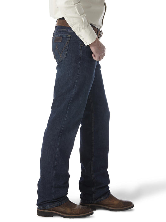 Man wearing dark wash straight leg jeans, brown belt, cowboy boots, and cream shirt