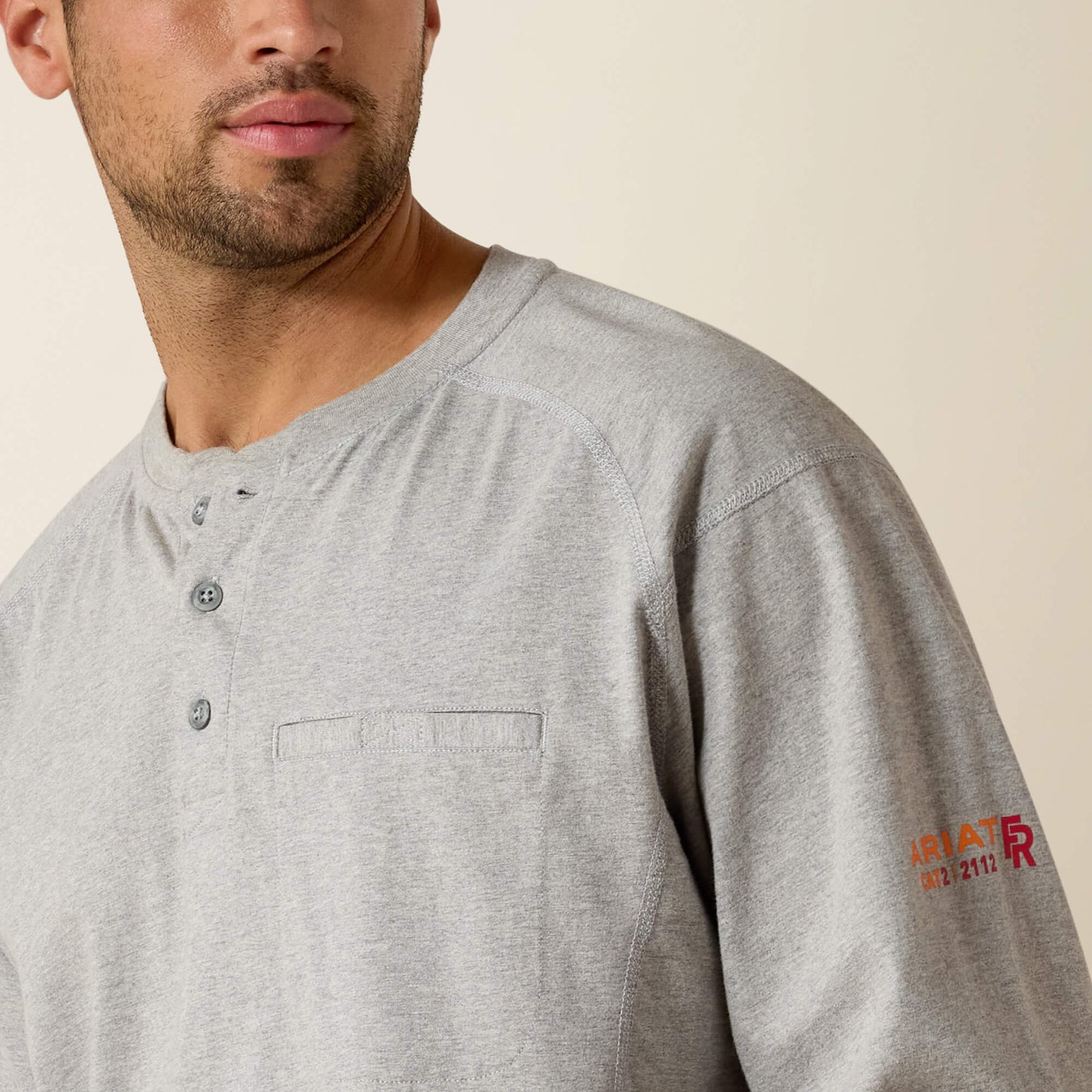 Gray long-sleeve shirt with a brand logo on a beige background
