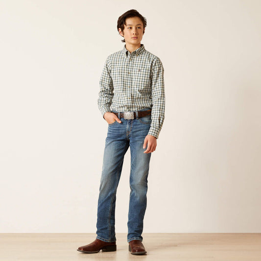 Man wearing a checkered shirt, blue jeans, and brown shoes on a plain background