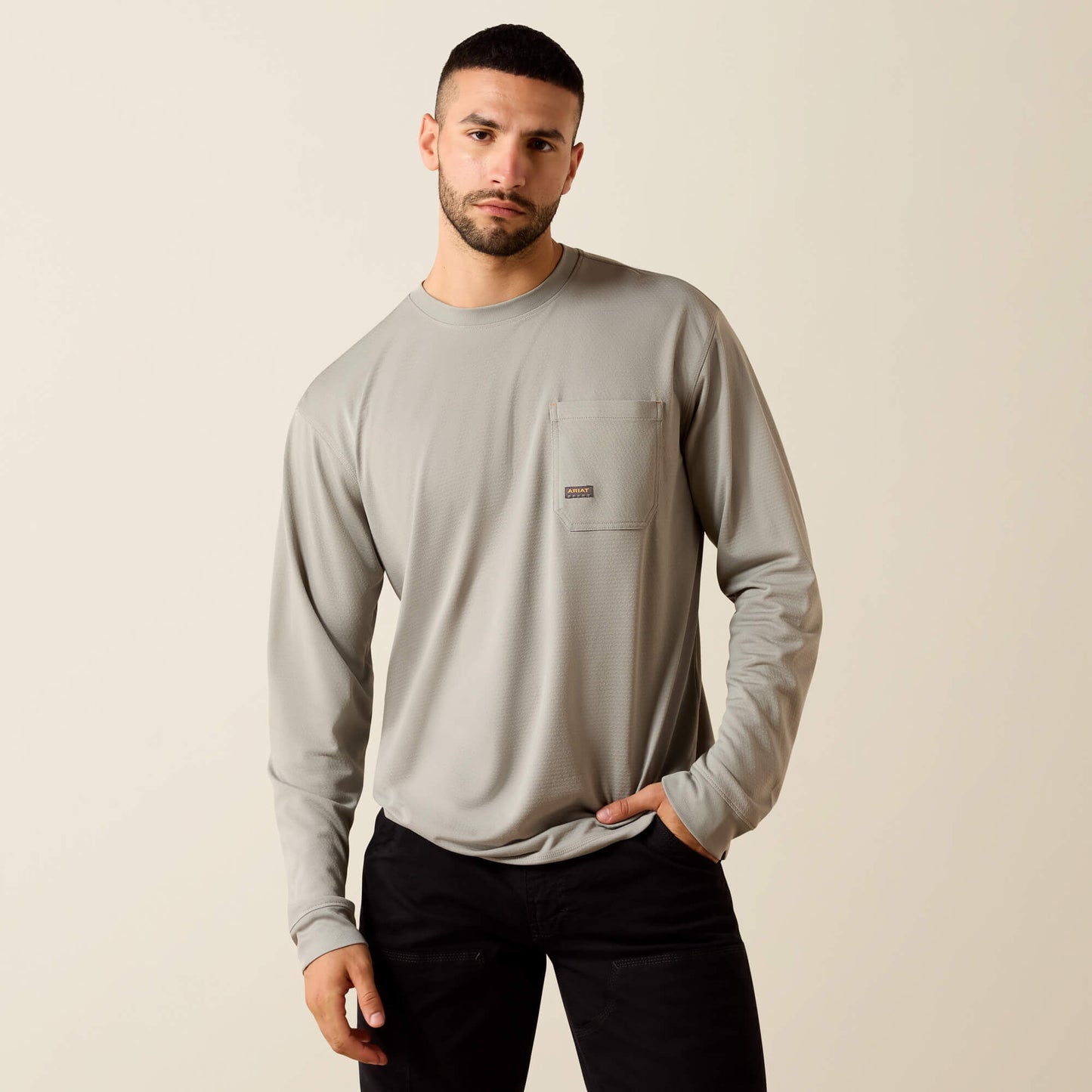 Man wearing a light grey long sleeve crew neck shirt with chest pocket