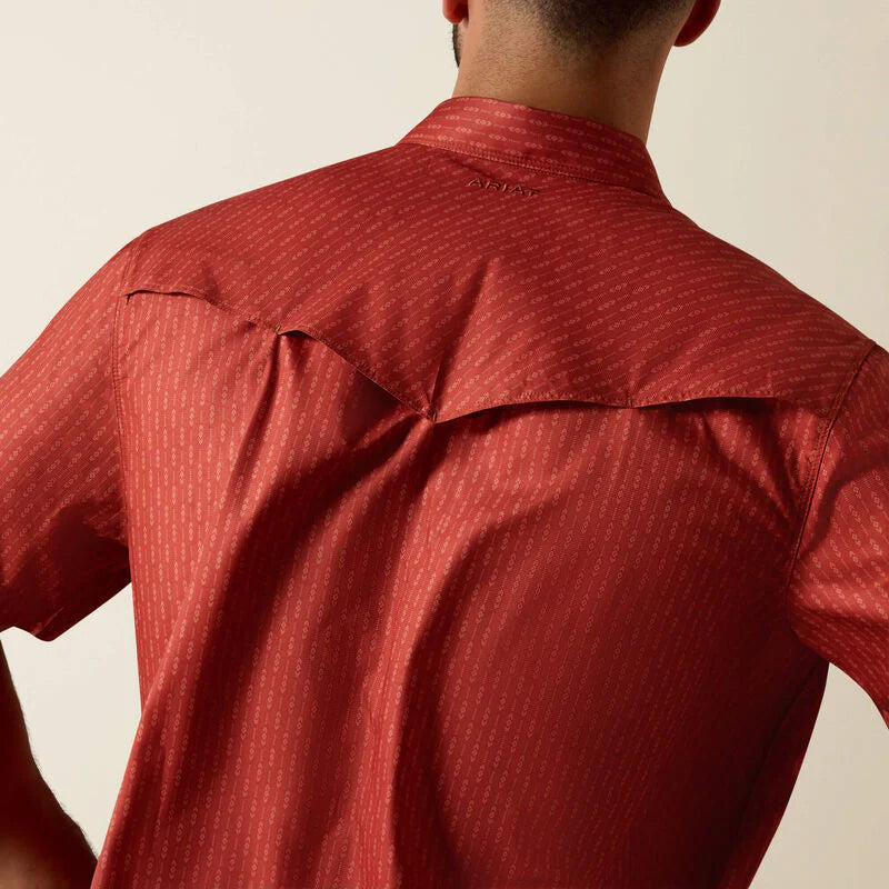 Red patterned shirt worn by a person on a beige background