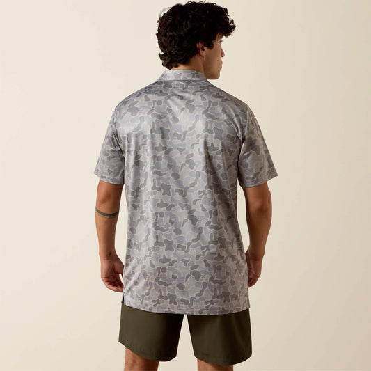 Man wearing a patterned shirt and shorts on a beige background