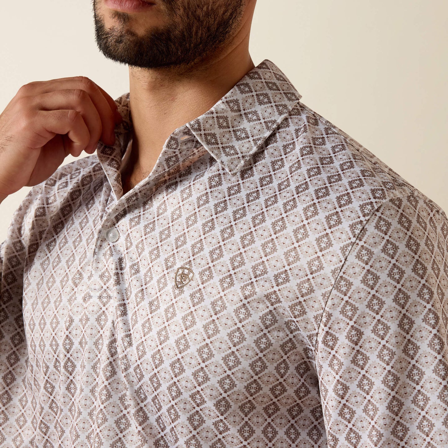 Man wearing a patterned shirt with a neutral background