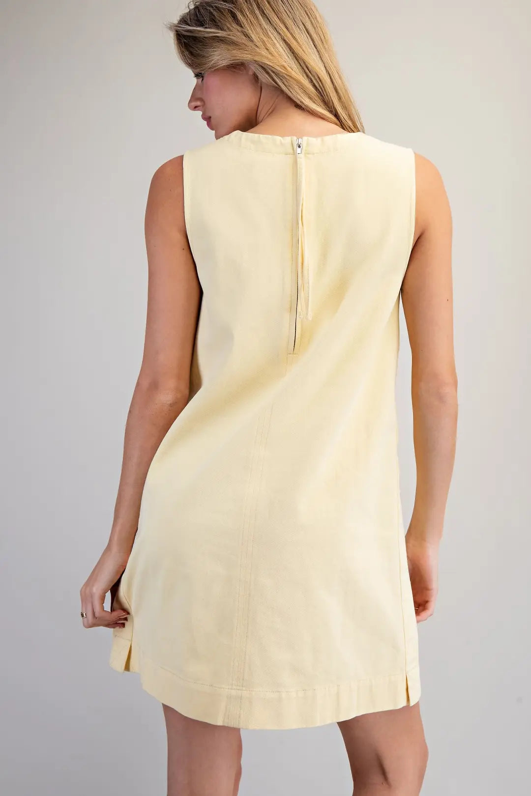 sleeveless shift dress features a simple round neckline and a minimalist A-line silhouette