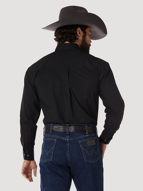 Man in black western shirt, blue jeans, and cowboy hat, seen from behind