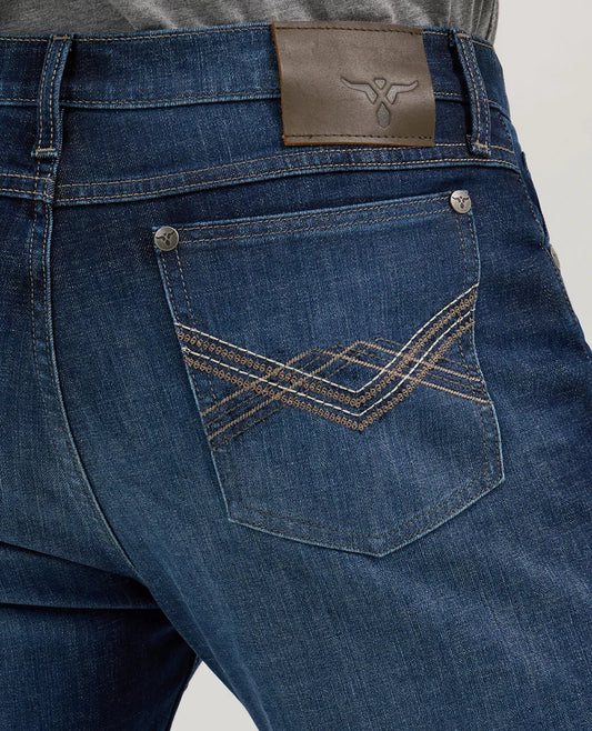 Close-up of blue denim jeans back pocket with decorative stitching and leather patch