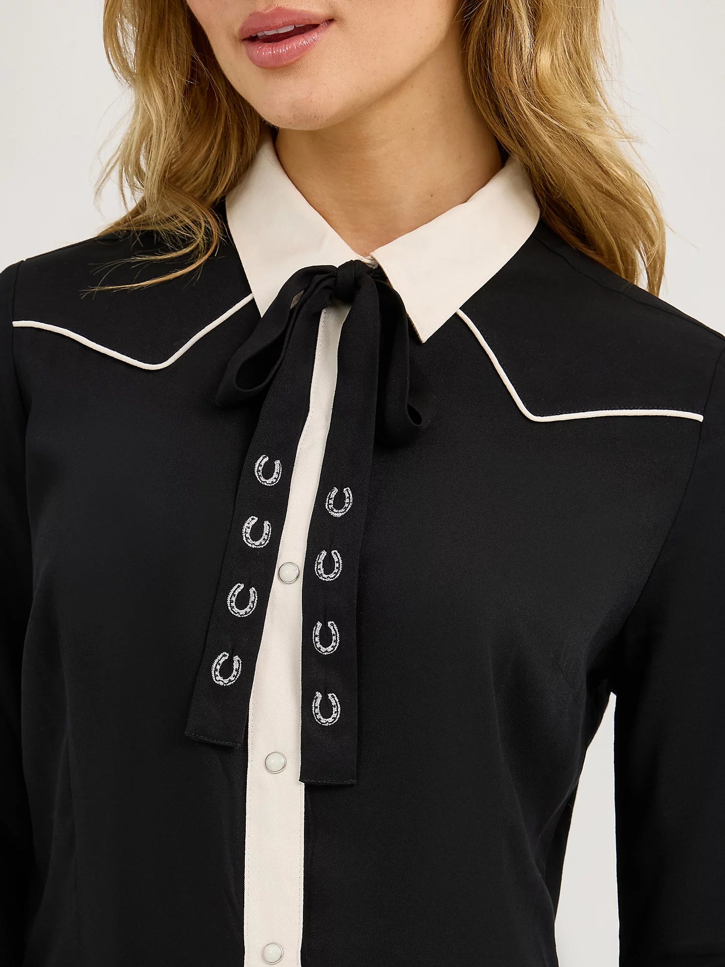 Women's western black shirt with white collar, bolo tie, and horseshoe embroidery details