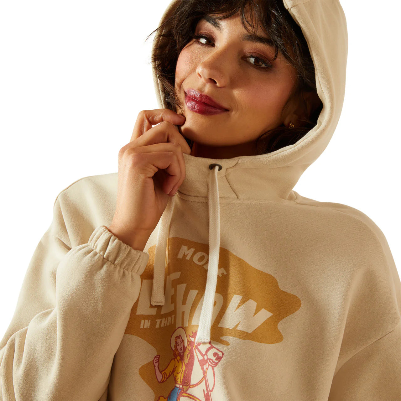 Woman wearing a beige graphic hoodie with drawstrings and colorful printed design
