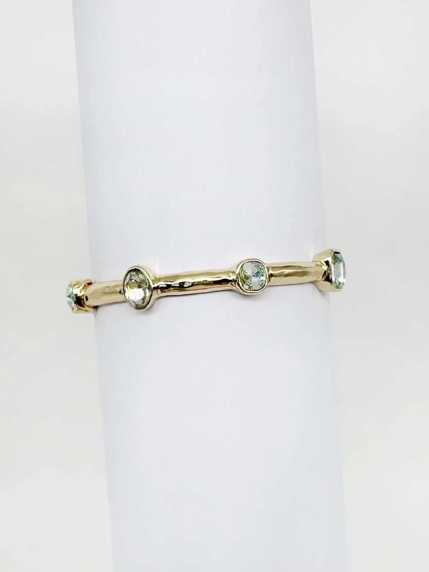 Gold bracelet with gemstones on a white background