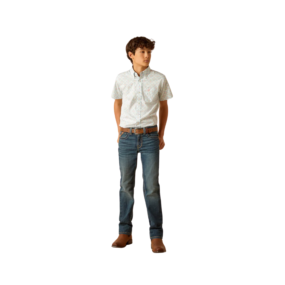 Boy wearing a short sleeve button-up shirt, blue jeans, and brown boots