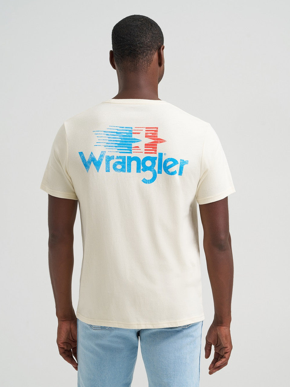 Person wearing a cream-colored t-shirt with Wrangler logo on the back against a white background