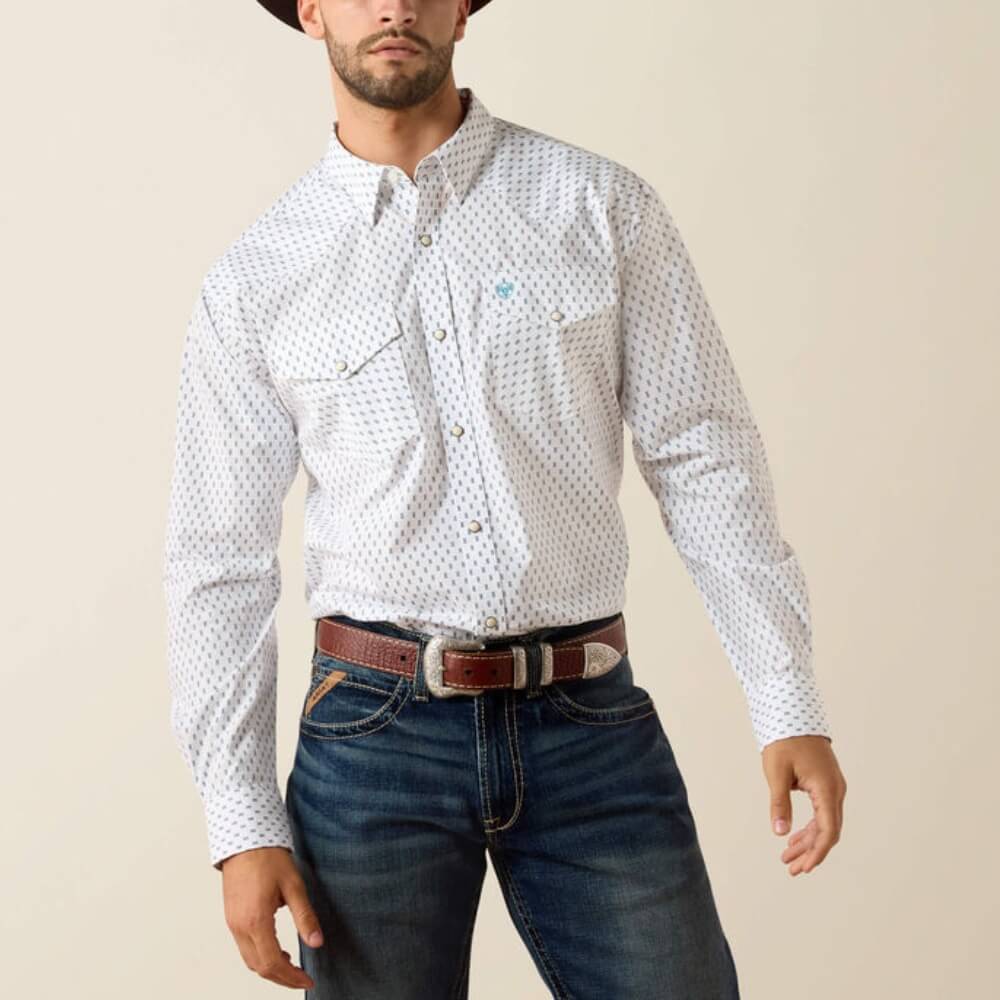 Man wearing a white patterned snap button western shirt, blue jeans, brown belt, and black hat.