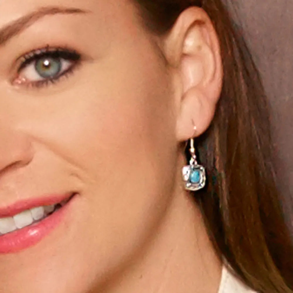 Close-up of a woman wearing a turquoise earring.
