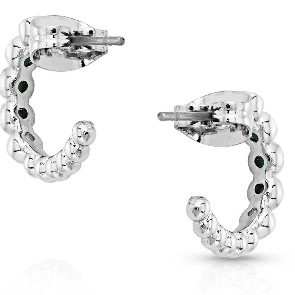 Textured silver hoop earrings with beaded design on white background