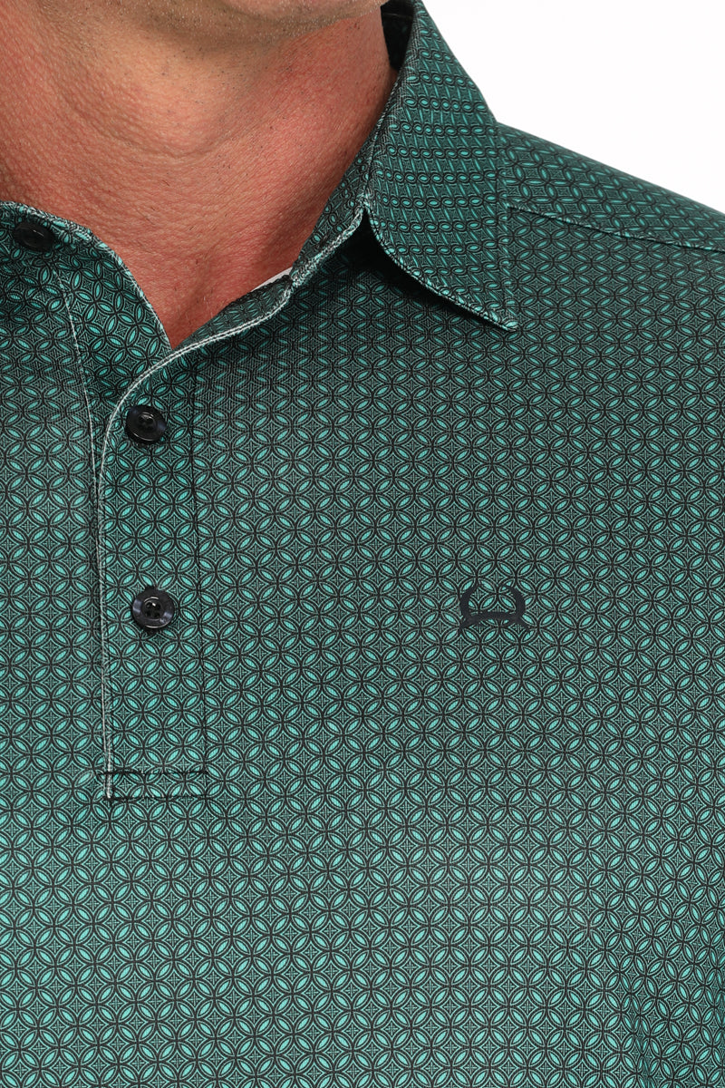 Close-up of green geometric patterned men's button-up shirt with small chest logo