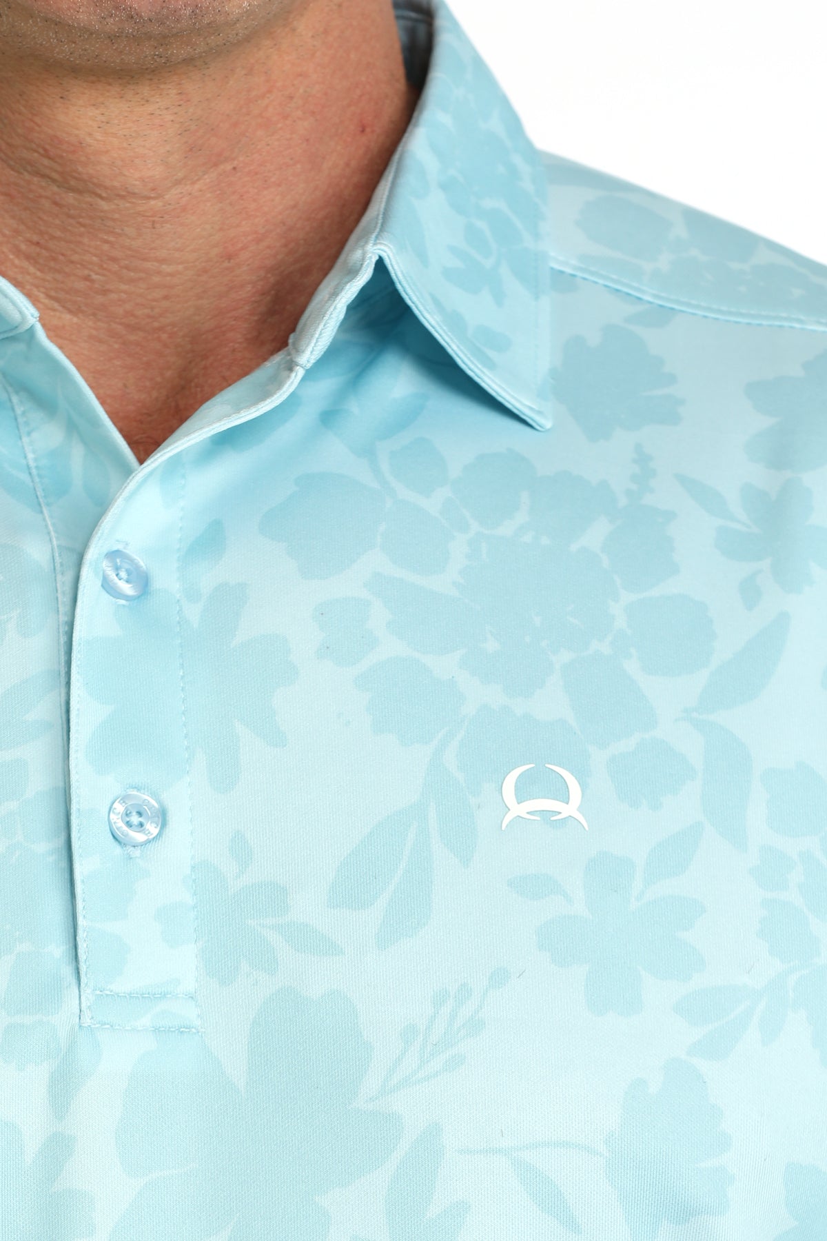 Light blue patterned polo shirt with a brand logo on a close-up of the collar.