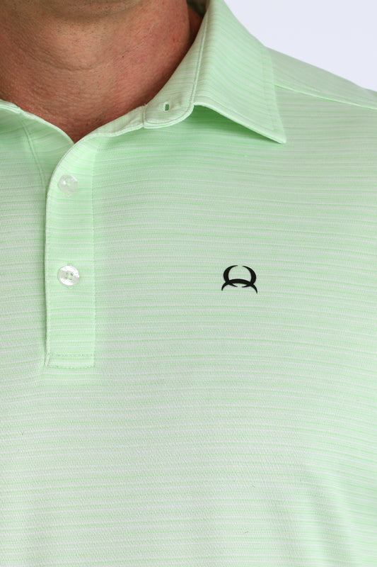 Close-up of a light green polo shirt with a small logo on the chest.