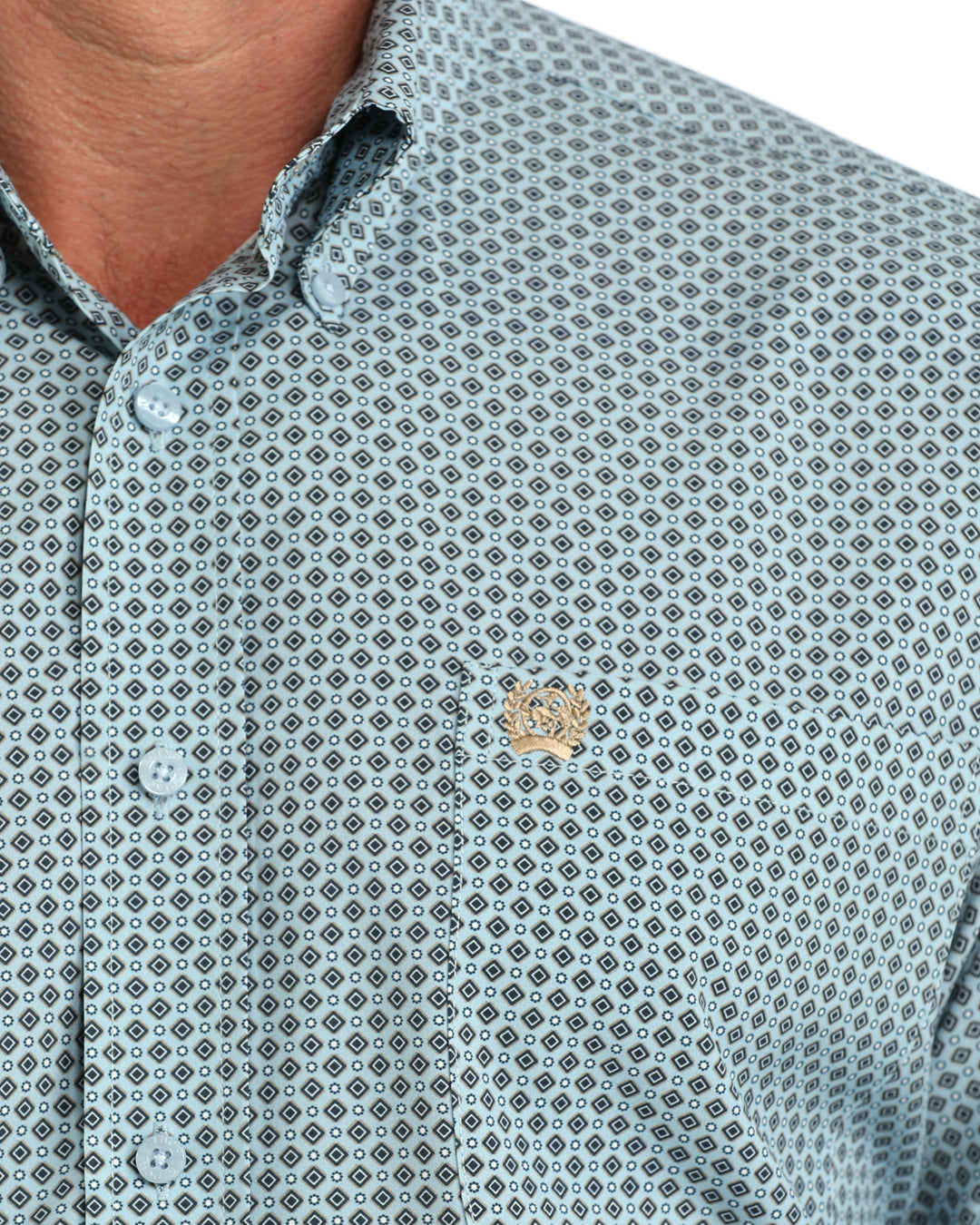 Close-up of a men's button-down shirt with a light blue and white geometric pattern and a small embroidered chest logo.