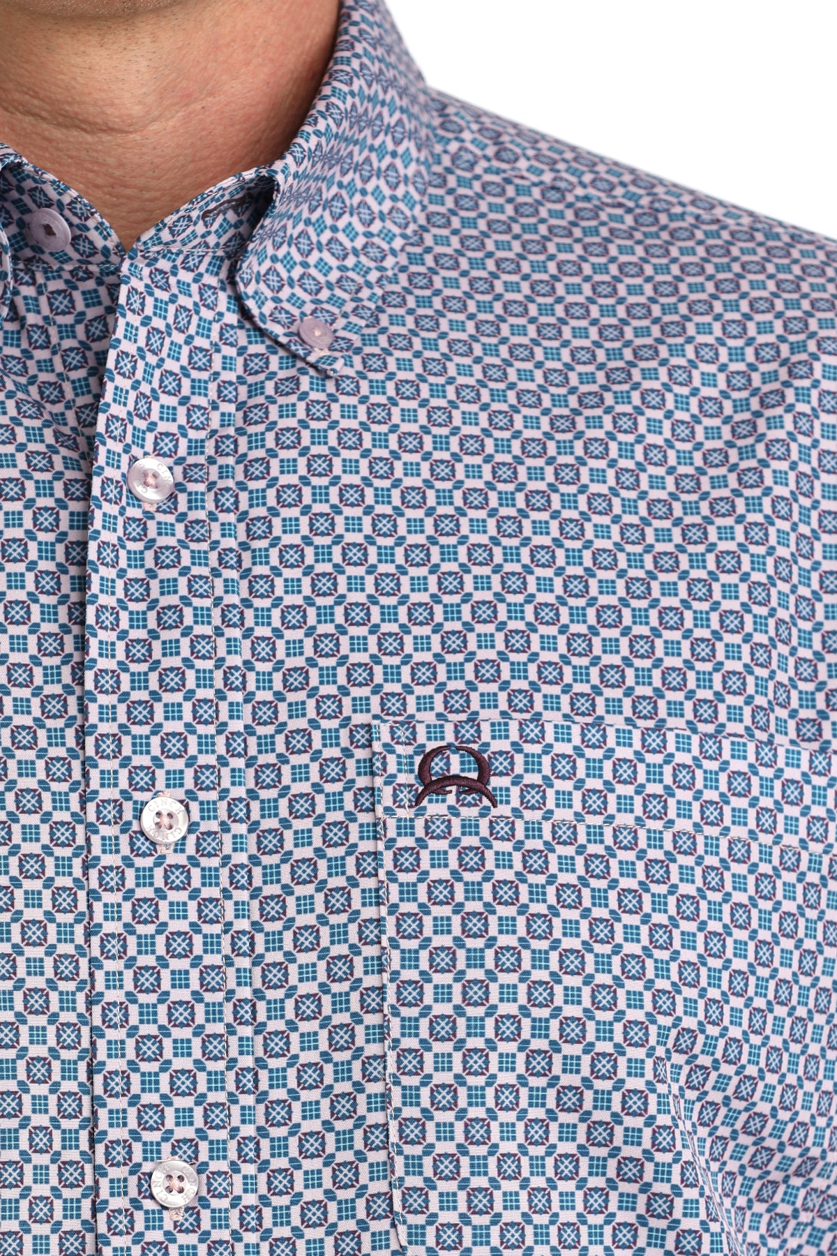 Close-up of a patterned shirt with a brand logo on a white background