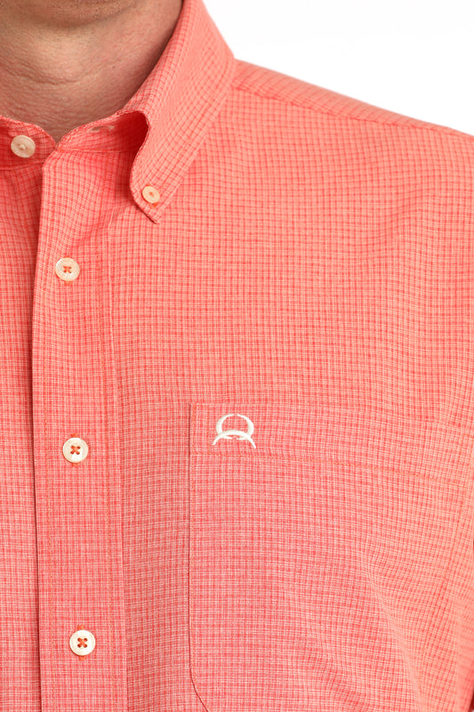 Close-up of a red checkered shirt with a small logo on a white background