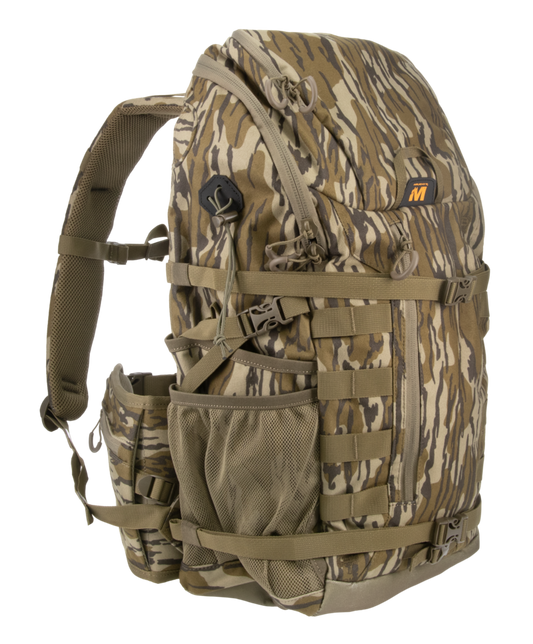 A camouflage backpack in a brown and tan woodland pattern, featuring multiple zippered compartments, webbing straps, and a side mesh pocket, shown against a plain white background.