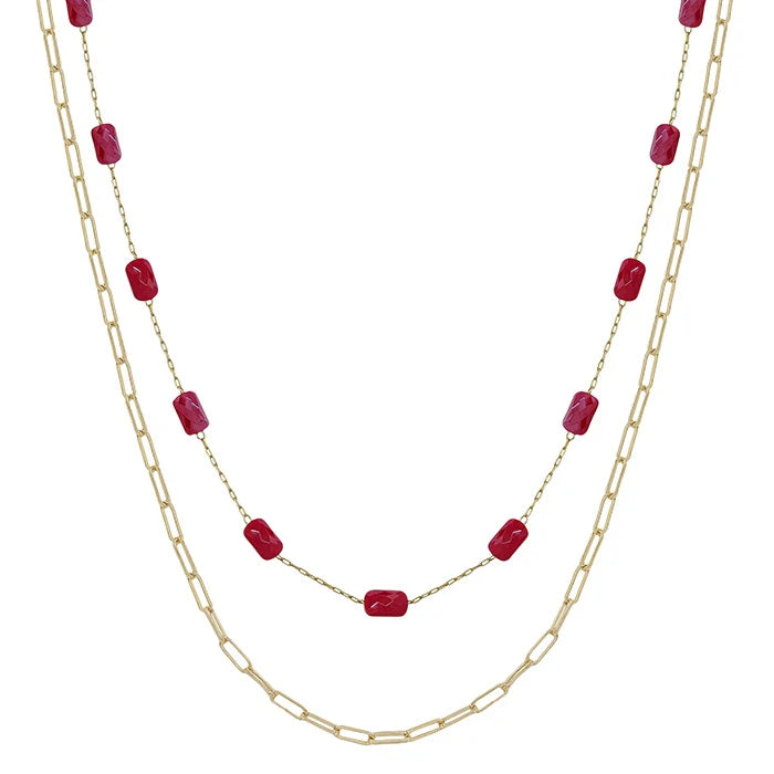 Two layered necklaces with gold chains and red beads on a white background