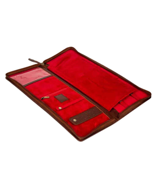 Open leather travel organizer with red interior, multiple pockets, and pen loops