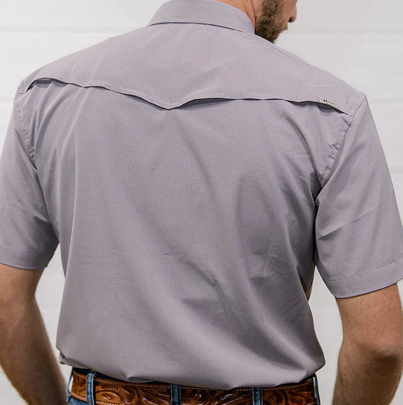 Man wearing a gray short-sleeve shirt with a subtle pattern against a plain background