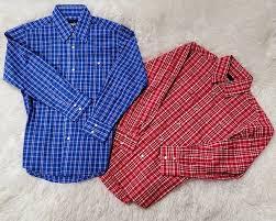 Blue and red plaid button-up shirts on light textured background