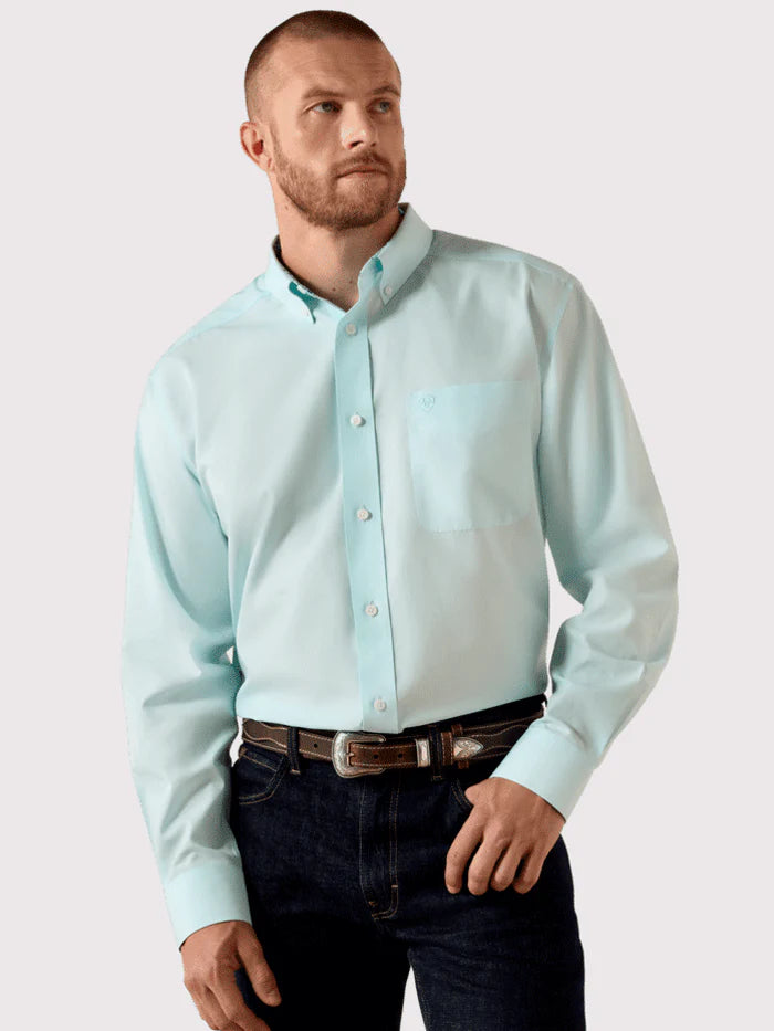 Man wearing light blue long sleeve button-down shirt and dark jeans, western casual style.