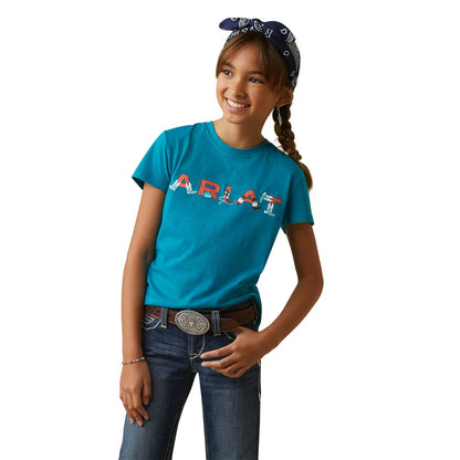 Smiling girl wearing blue graphic tee, jeans, western belt, and a navy bandana headband