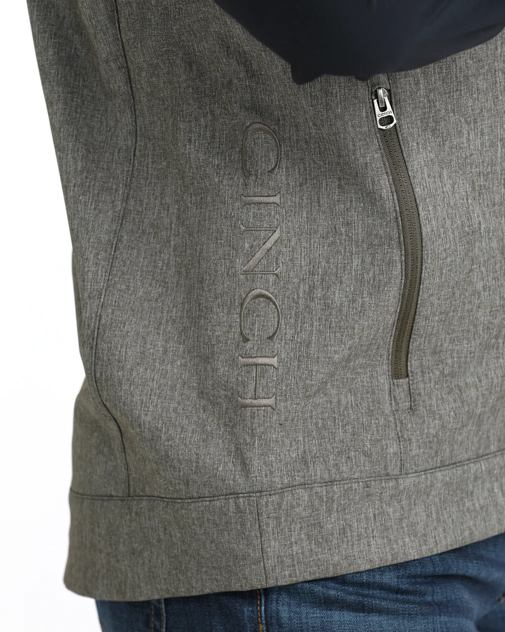 Close-up of gray softshell jacket with vertical zipper pocket and embroidered CINCH logo