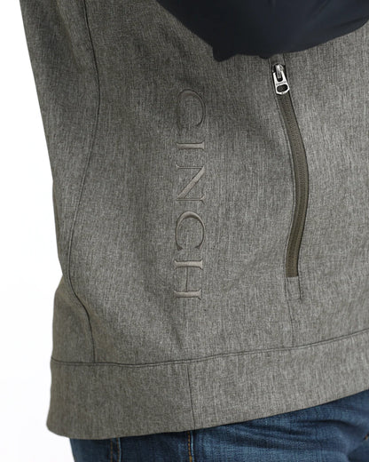 Close-up of gray softshell jacket with vertical zipper pocket and embroidered CINCH logo