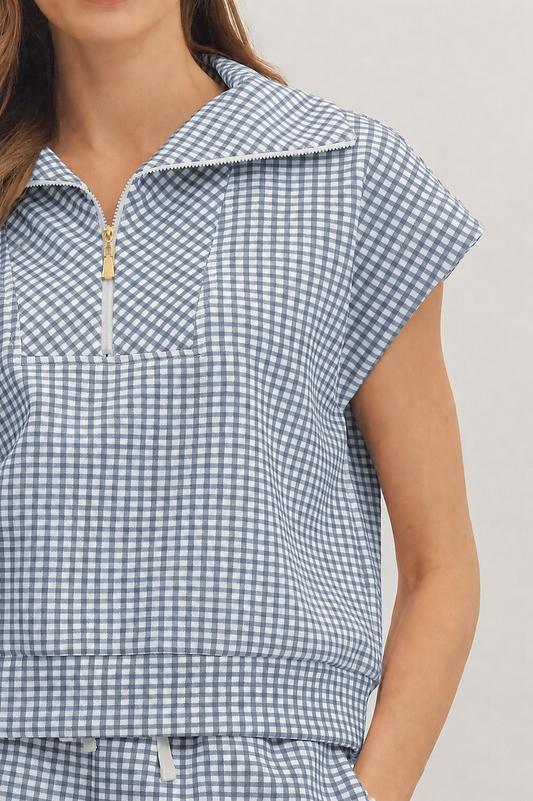 Blue and white checkered sleeveless top on a plain background