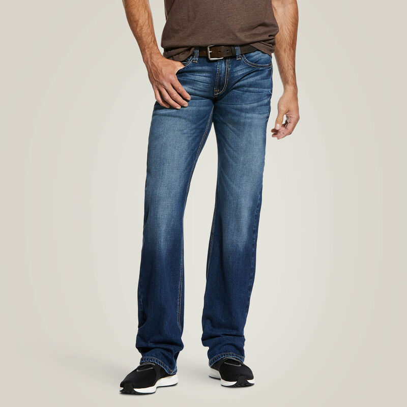 Person wearing blue jeans on a plain background