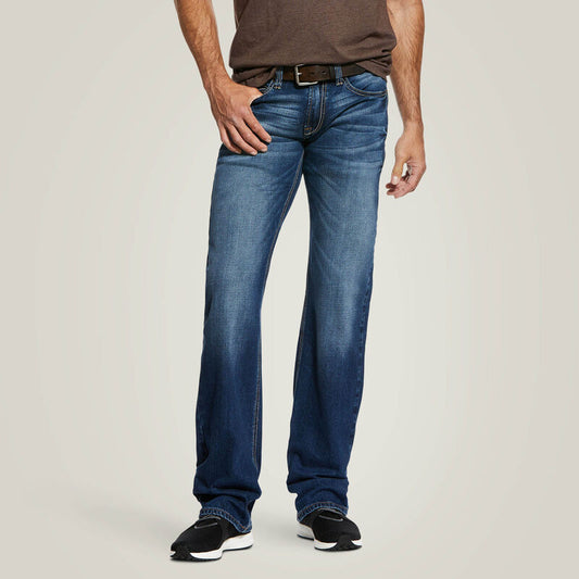 Person wearing blue jeans on a plain background