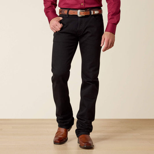 Person wearing a red shirt, black pants, and brown shoes on a beige background