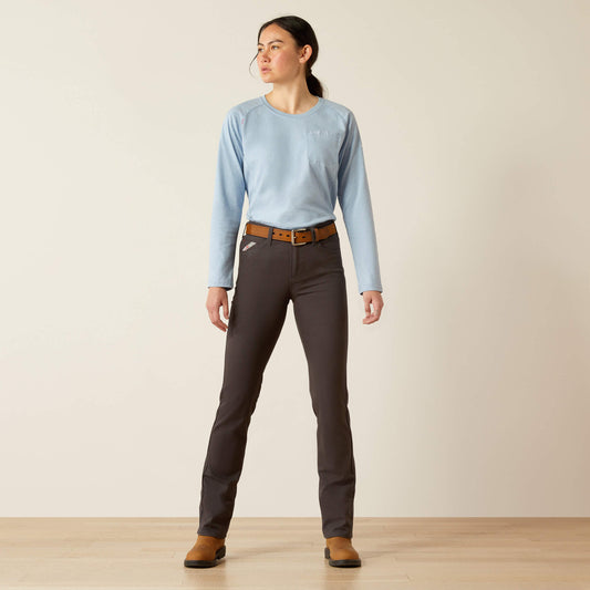 Woman wearing a light blue shirt, dark gray pants, and brown shoes on a plain background