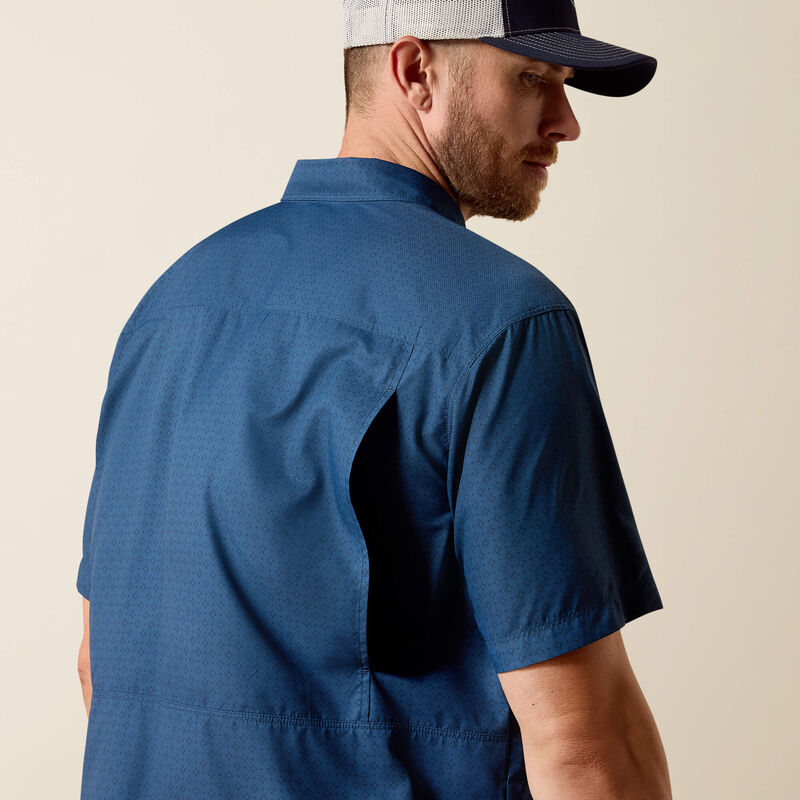 Man wearing a blue shirt and cap on a beige background