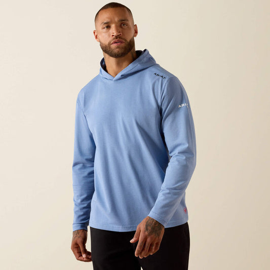 Man wearing a light blue hoodie with a brand logo on a beige background