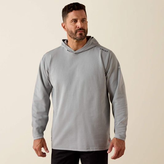Man wearing a gray hoodie with a brand logo on a beige background