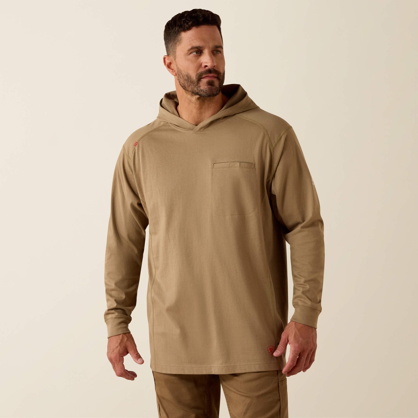 Man wearing a beige hoodie and pants on a beige background