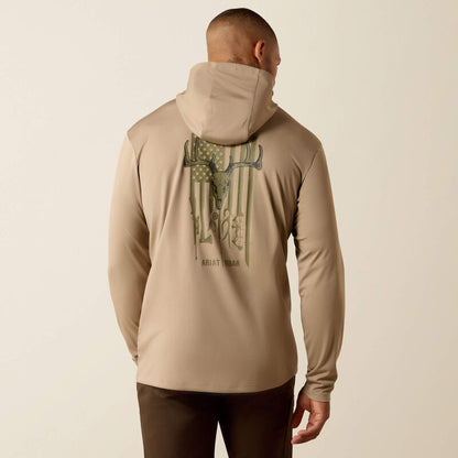 Man wearing a beige hoodie with a graphic design on the back against a beige background