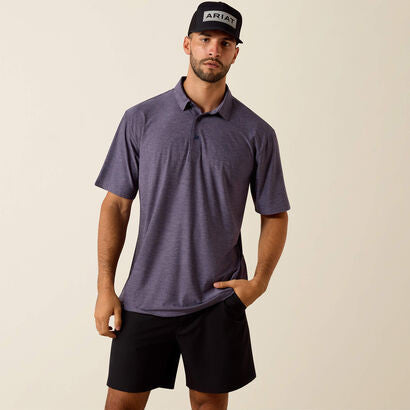 Man wearing a purple polo shirt and black shorts with a beige background
