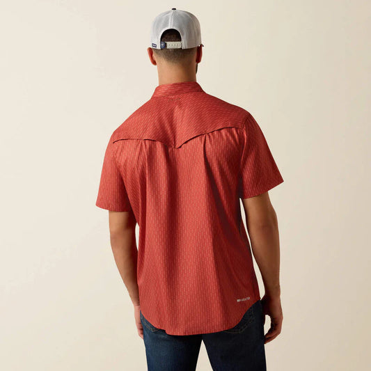 Person wearing a red short-sleeve shirt and a cap on a beige background