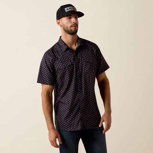 Man wearing a patterned shirt and cap on a beige background