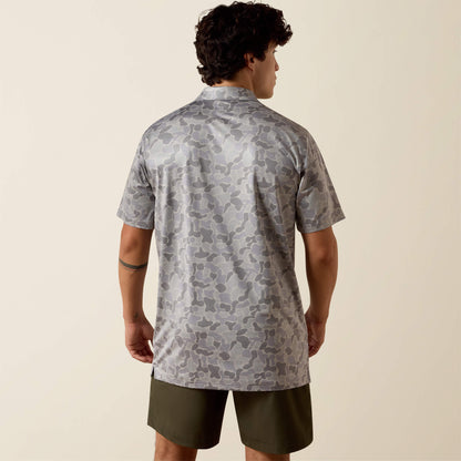 Man wearing a patterned shirt and shorts on a beige background
