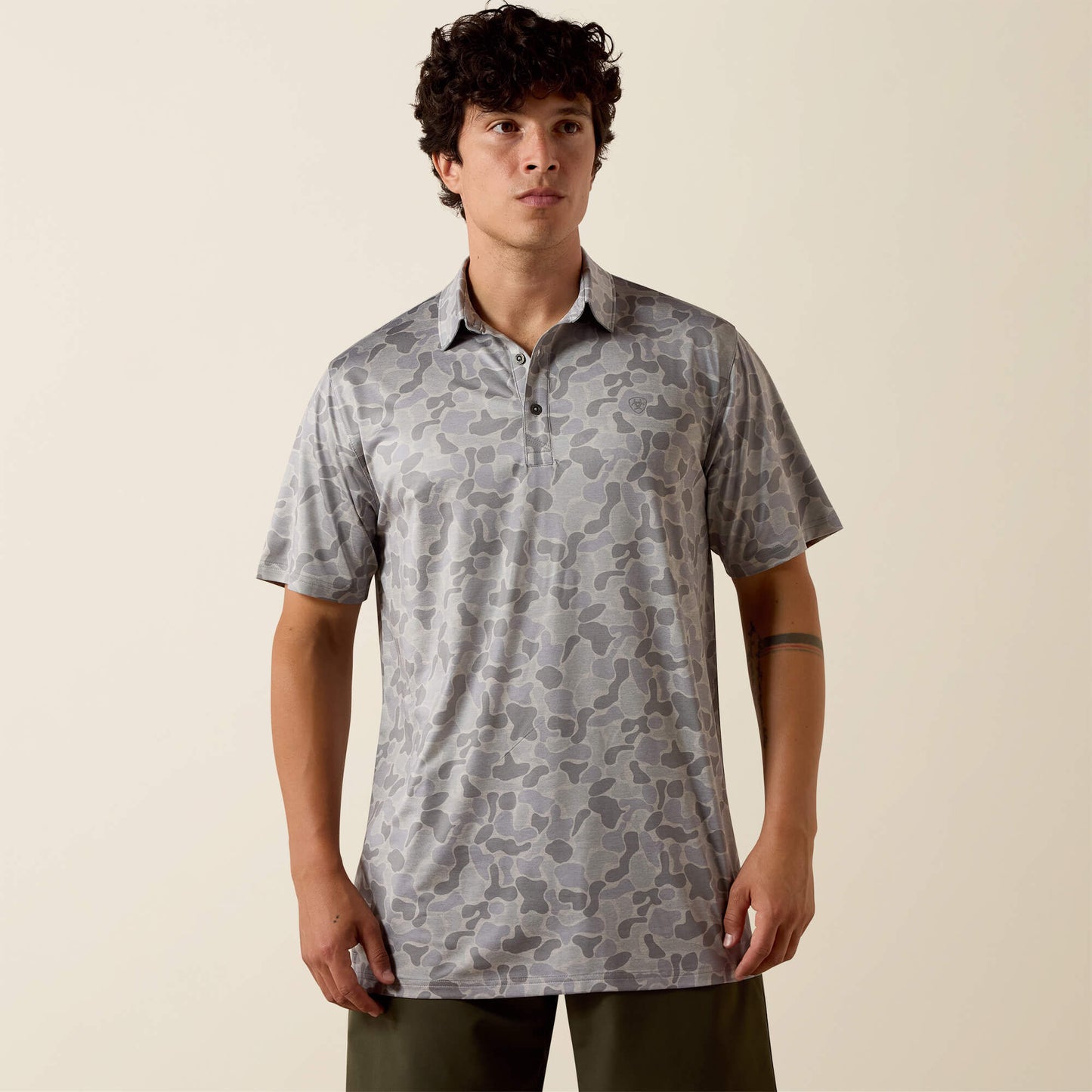 Man wearing a patterned shirt against a beige background