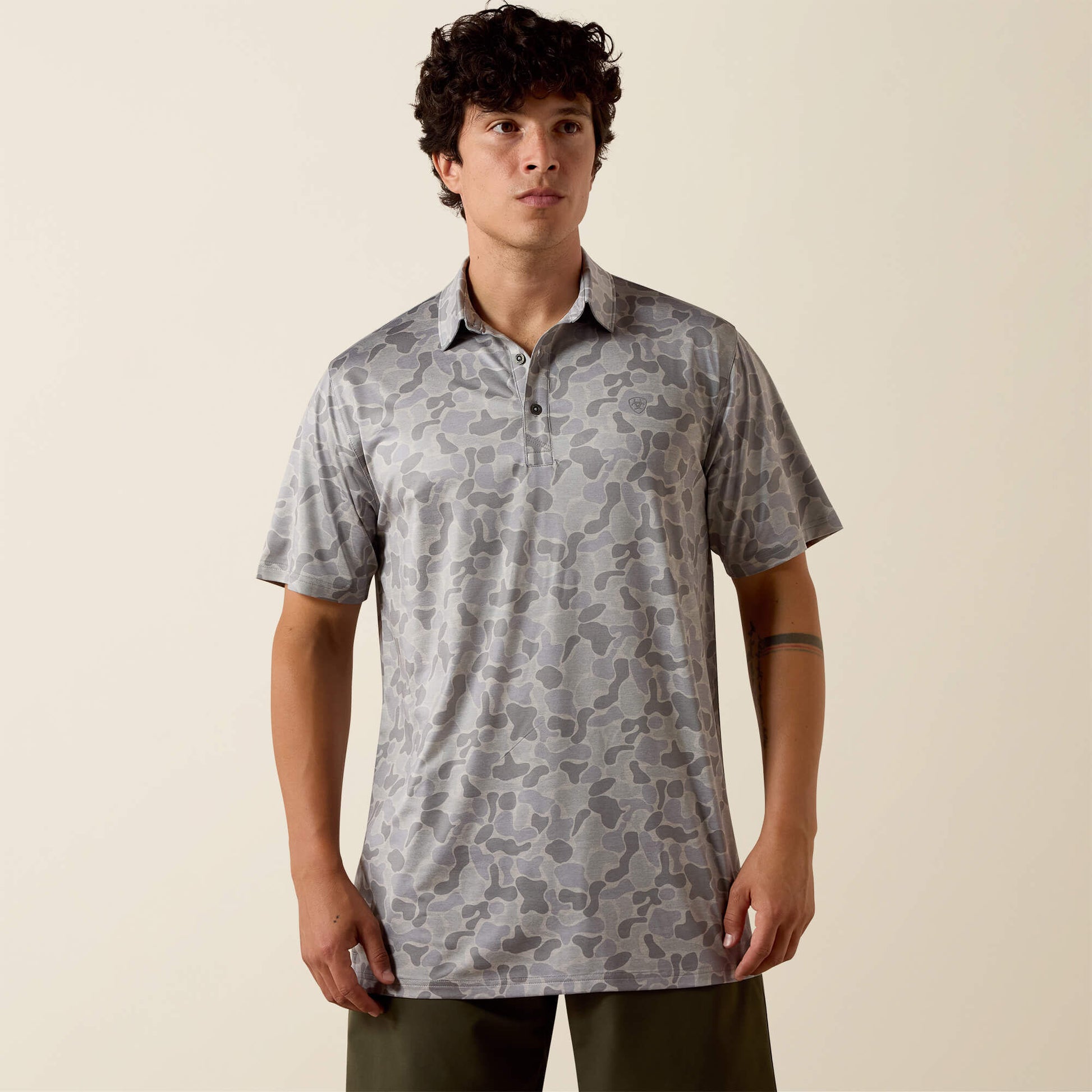 Man wearing a patterned shirt against a beige background