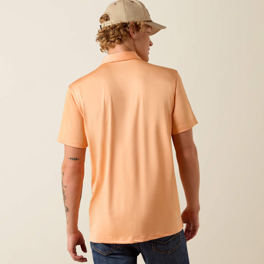 Person wearing a peach polo shirt and beige cap on a plain background